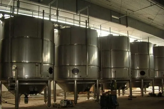A group of large metal tanks in a room.