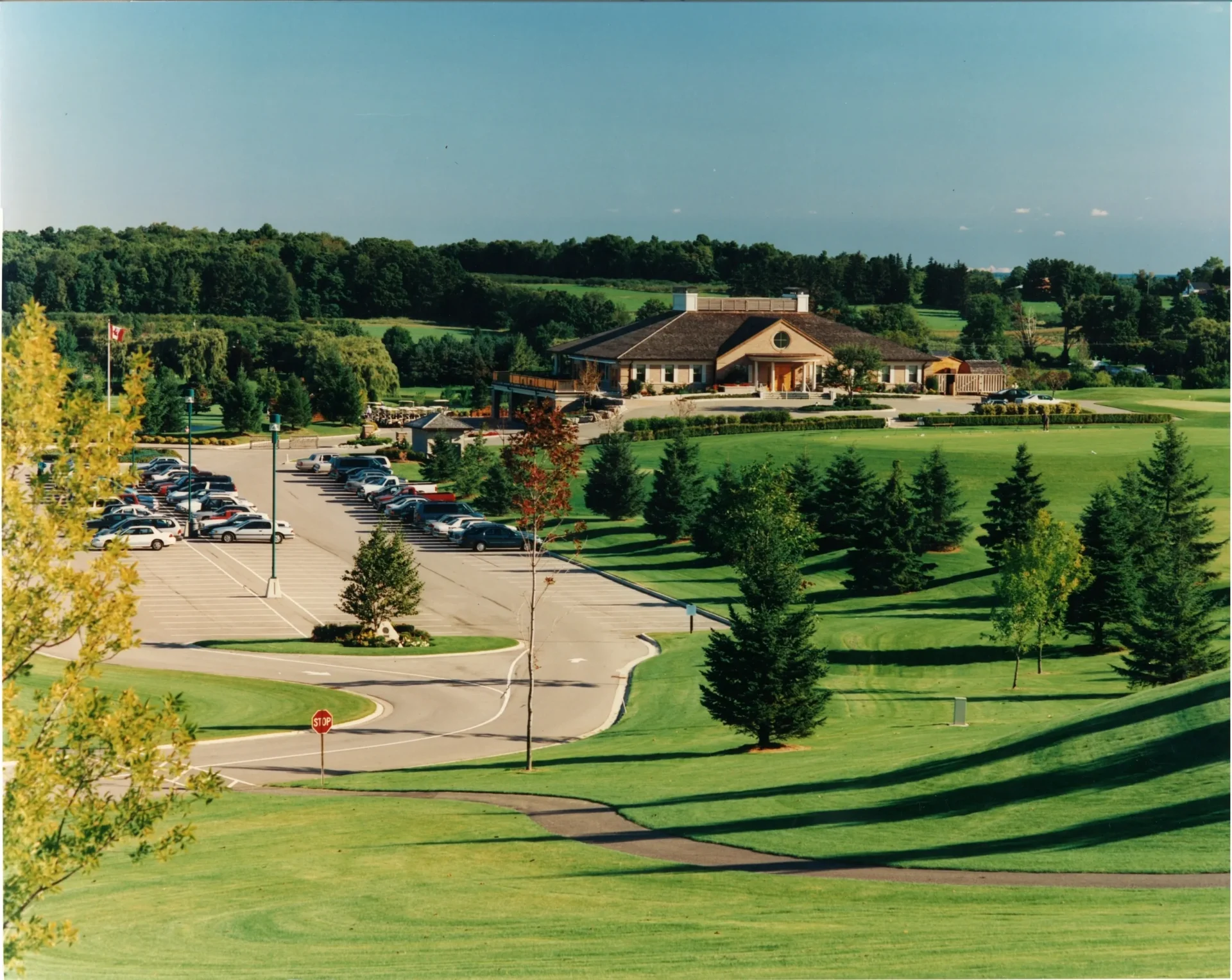 A view of a golf course with many trees.